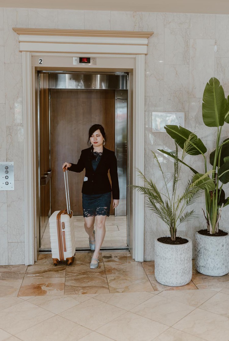 Woman exiting elevator with luggage