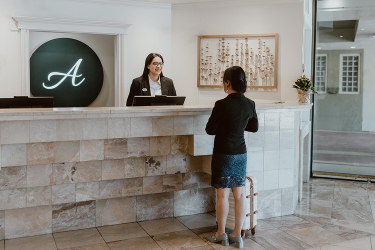 Woman checking in and receptionist behind desk