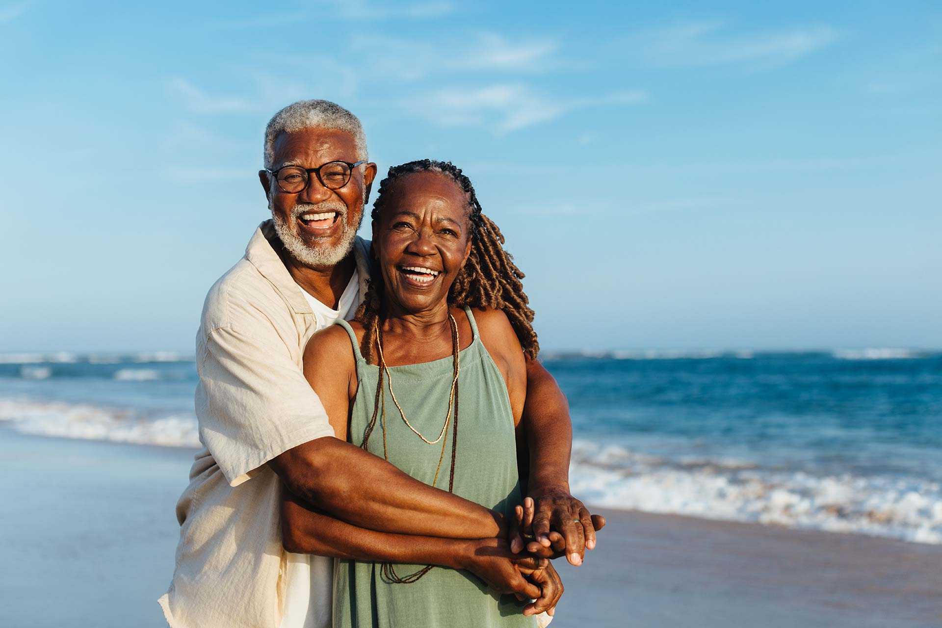 A senior couple hugging on the beach