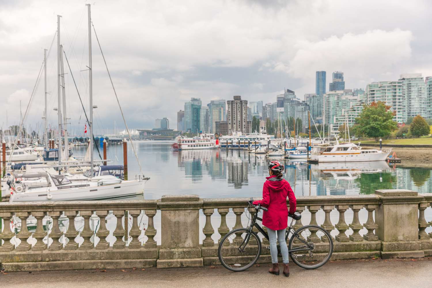A woman with her bike looks out onto the harbour